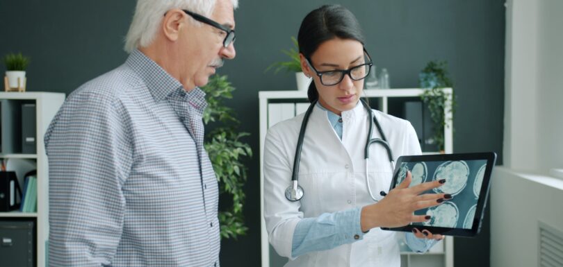 Doctor shows medical scan to elderly patient